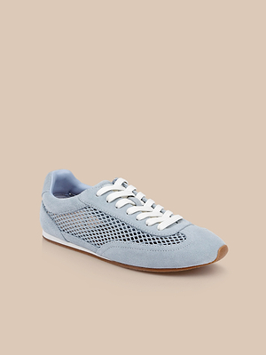 The Jarah Sneaker, a retro-inspired shoe in light blue with white laces, mesh side panels, suede accents, and a brown rubber sole, is shown on a beige background.