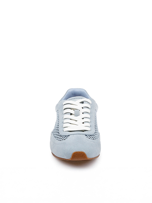 The Jarah Sneaker is displayed facing forward on a white background, featuring retro-inspired design in light blue with white laces, a brown sole, and mesh and suede material details.