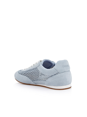 The Jarah Sneaker features retro-inspired light blue suede, white laces, mesh side panels, and a white sole with a tan bottom. It’s angled to show the back and side, with LAGENCE embossed on the heel.