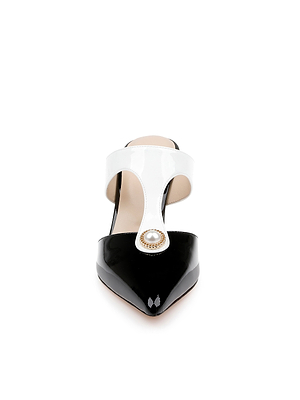 Front view of the Bayonne Mule—a stylish black and white leather mule featuring a pointed heel, glossy black toe, white instep strap, and decorative pearl accent—set against a plain white background.