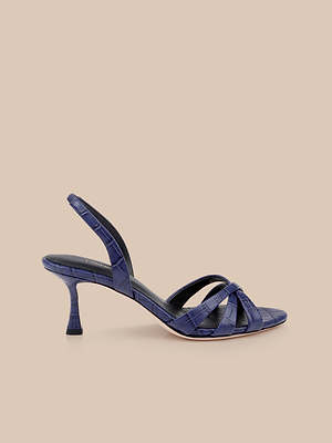 The Colwill Slingback Sandal, shown in navy blue with a croc-embossed finish, mid heel, open toe, crisscross front straps, and slingback strap, is displayed on a beige background.