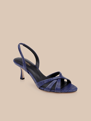 The Colwill Slingback Sandal, a strappy croc-embossed style in shiny dark blue with a mid heel and slingback strap, is displayed on a neutral beige background.