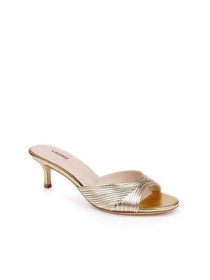 The Chamonix Kitten-Heel Mule features an open toe, low gold-silver heel, and metallic crisscross straps, shown against a white background.
