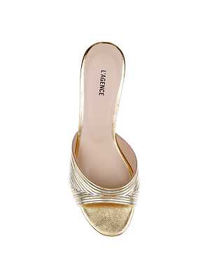 The Chamonix Kitten-Heel Mule is a gold open-toe slide with crisscross metallic straps, a beige insole branded LAGENCE, and photographed from above on a white background.