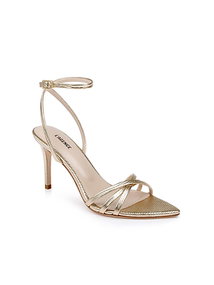 The Dua Leather Sandal showcases gold lizard-embossed leather with a pointed toe, stiletto heel, slim ankle strap, and chic strappy design featuring two thin crossing straps over the front, set against a white background.