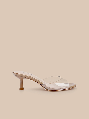 The Esther Kitten-Heel Mule features a clear vinyl upper and beige sole, shown in side profile against a light beige background.