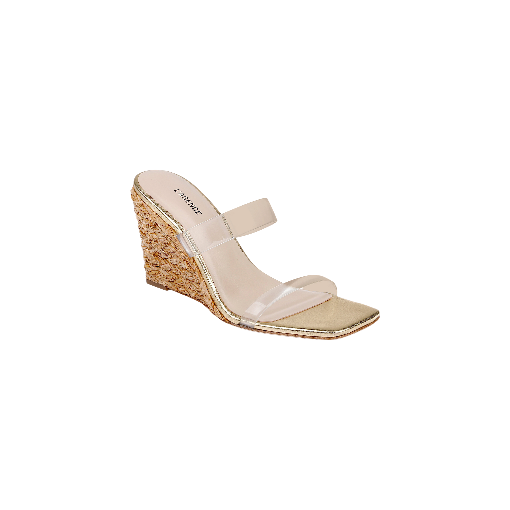 The Farrell Wedge Espadrille features a gold finish with a woven raffia wedge heel, square toe, and two clear straps across the top, displayed on a white background.