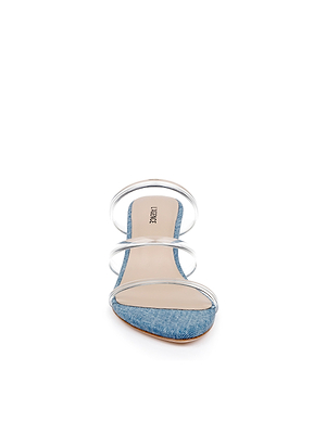 The Ludovica Kitten-Heel Sandal features a light blue denim sole, three clear vinyl straps, and a beige insole. Displayed against a white background, it’s ideal for minimalist shoe lovers.