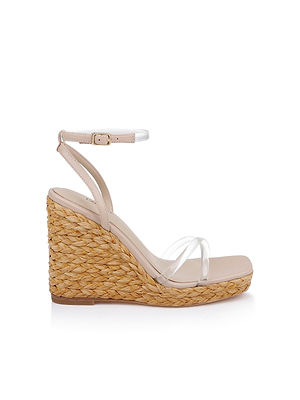 The Malone Wedge Espadrille features a braided raffia wedge heel, nude footbed, clear toe strap, and a nude ankle strap with buckle, shown in profile against a white background.