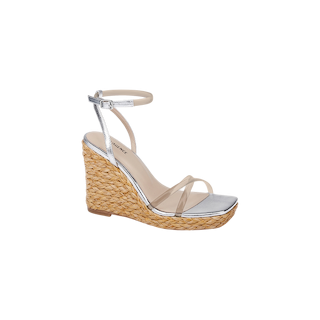 The Malone Wedge Espadrille is a single espadrille wedge sandal featuring a braided raffia heel, metallic silver ankle strap, and clear toe strap, displayed on a plain white background.