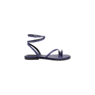 The Mariana Leather Sandal is a purple, flat leather sandal with a textured pattern, shown in a side profile view on a plain white background. It features a toe loop, single front strap, and an ankle strap with buckle closure.