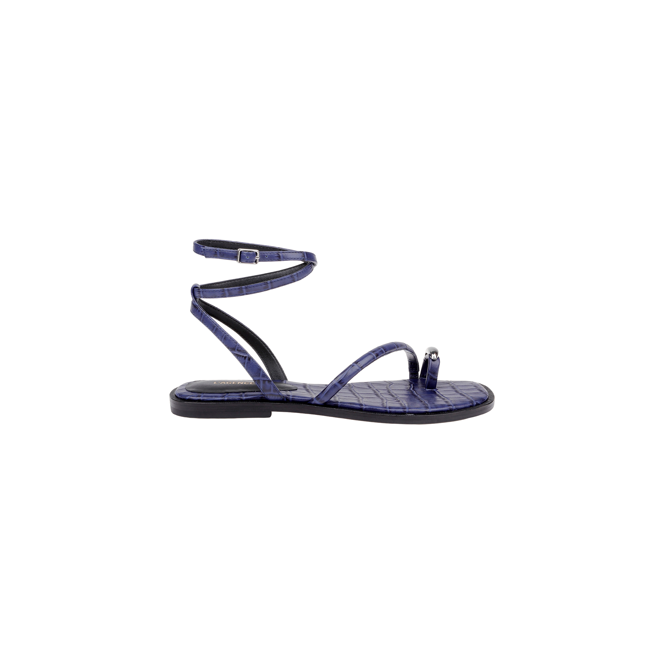 The Mariana Leather Sandal is a purple, flat leather sandal with a textured pattern, shown in a side profile view on a plain white background. It features a toe loop, single front strap, and an ankle strap with buckle closure.