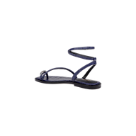 The Mariana Leather Sandal, a navy croc-embossed design featuring thin straps and an ankle tie flat strap that wraps around the ankle, is displayed in a side view against a plain white background.
