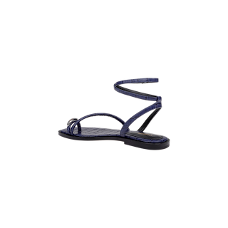 The Mariana Leather Sandal is a single flat sandal in dark blue, featuring a thin, strappy design and an ankle wrap strap, displayed on a plain white background.