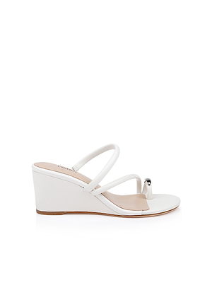 The Maritza Wedge Sandal features a white minimalist design with two thin straps, an open toe, a metallic accent on the front strap, and a comfortable wedge heel, displayed against a plain white background.