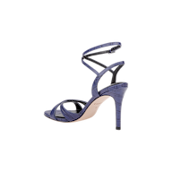 The Miranda Leather Sandal is a high-heeled sandal crafted in glossy purple leather with a crocodile texture, showcasing crisscross straps and an ankle-wrap closure, displayed from the side against a white background. Perfect for complementing evening gowns.