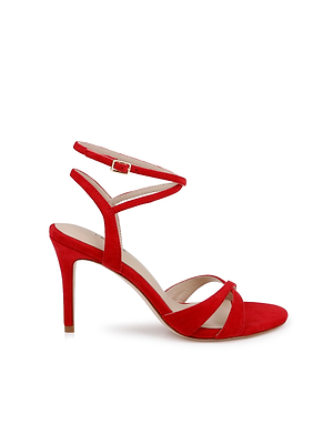 The Miranda Suede Sandal is a red high-heeled sandal featuring crisscross front straps, an open toe, and a thin ankle-wrap strap with buckle—an elegant choice for evening events—shown against a white background.