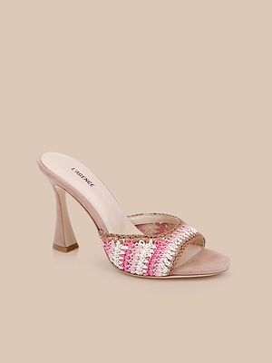 The Moyes Crochet Sandal is a high-heeled mule with a sculpted heel, light beige sole, and a woven strap in pink, white, and beige—ideal for summer style, shown on a plain beige background.