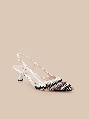 The Nantes Slingback Pump features a pointed toe, woven multicolor pattern in black, brown, and beige, a white strap, memory foam insole, and a low angled heel set against a light beige background.