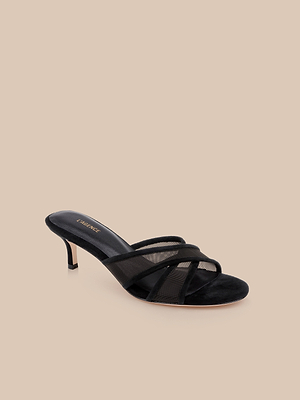 The Padua Mesh Sandal is a black heeled sandal with mesh and suede straps, leather lining, an open toe, and a slim stiletto heel, shown against a plain beige background.