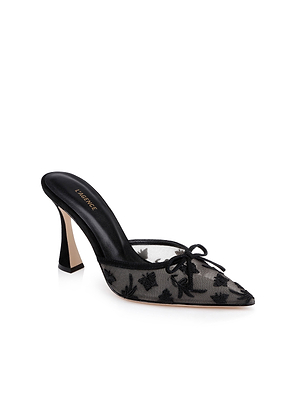 The Prasad Mesh Mule is a black mesh mule with a pointed toe, sheer upper featuring floral and butterfly embroidery, a small front bow, sculpted high heel, and a black Versace-labeled insole.