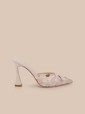 The Prasad Mesh Mule is a pale pink high-heeled mule with an open back, pointed toe, and delicate butterfly embroidery set against a matching pale peach mesh for an elegant, intricate look.