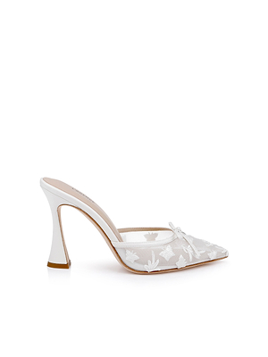The Prasad Mesh Mule features a white pointed toe, mesh upper with delicate floral embroidery, a small bow, and a flared high heel—combining femininity and style in one elegant shoe.