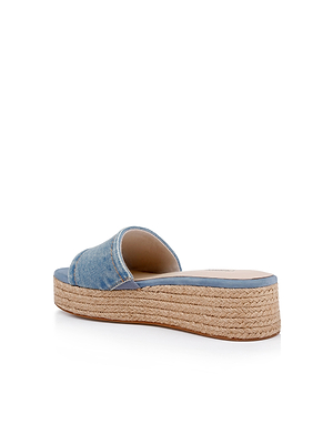 The Ramani Platform Espadrille features a blue denim upper, open toe, and thick platform sole wrapped in braided jute—shown from the back against a white background. Perfect for spring and summer looks.