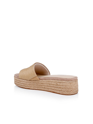The Ramani Platform Espadrille features a beige woven straw upper and a thick braided espadrille sole. Shown from the back on a white background, it’s the perfect slide sandal for effortless warm-weather style.