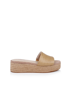 The Ramani Platform Espadrille is a tan slide sandal with a woven texture, open toe, and wide strap—evoking classic raffia styles. Perfect for warm weather, its shown on a white background.