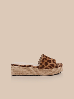 The Ramani Platform Espadrille features a printed suede leopard strap and woven jute sole on a flat platform slide, shown against a light beige background—ideal for effortless summer style.