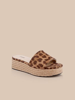 The Ramani Platform Espadrille features a thick jute-wrapped flat sole and a wide leopard-print suede strap, shown against a beige background—ideal for easy summer style.