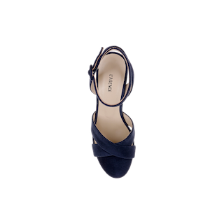The Sandrine Platform Sandal is a single navy suede heeled sandal with crisscross straps and an ankle buckle, viewed from above on a white background. The beige insole is labeled LAGENCE, while a raffia-wrapped wedge adds natural texture to this sophisticated platform sandal.
