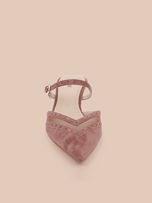 The Shelbie Kitten-Heel Mule in pinkish-brown suede, featuring a pointed toe, ankle strap, and brogue details, is shown against a light beige background.