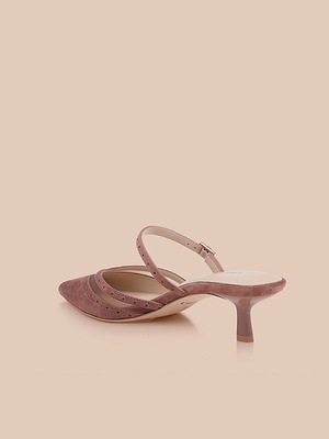 The Shelbie Kitten-Heel Mule in mauve features a pointed toe, suede finish, kitten heel, and a single thin ankle strap, shown against a light beige background.