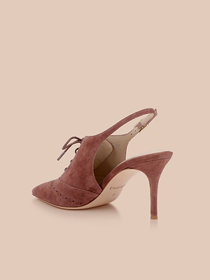 The Shreya Suede Slingback Pump features a mauve suede upper, pointed toe, lace-up front, cut-out sides, and a slingback strap with gold buckle, displayed on a beige background.