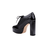 The Tania Oxford Pump is a black patent leather platform oxford with a thick block heel, lace-up front, brogue detailing, and a beige sole, shown in side profile on a plain white background.
