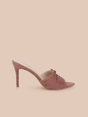 The Thames Suede Sandal is a mauve suede high-heeled mule with a pointed toe, lace-up detail, and stiletto heel, shown against a light beige background.