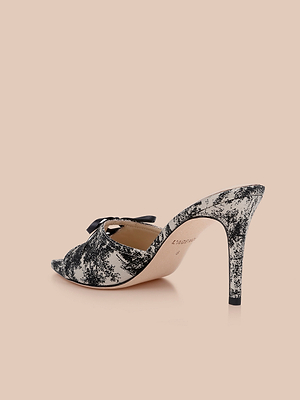 The Thames Sandal, a high-heeled mule with a bold black and white marbled pattern, open toe, and sleek stiletto heel, is displayed on a light beige background.