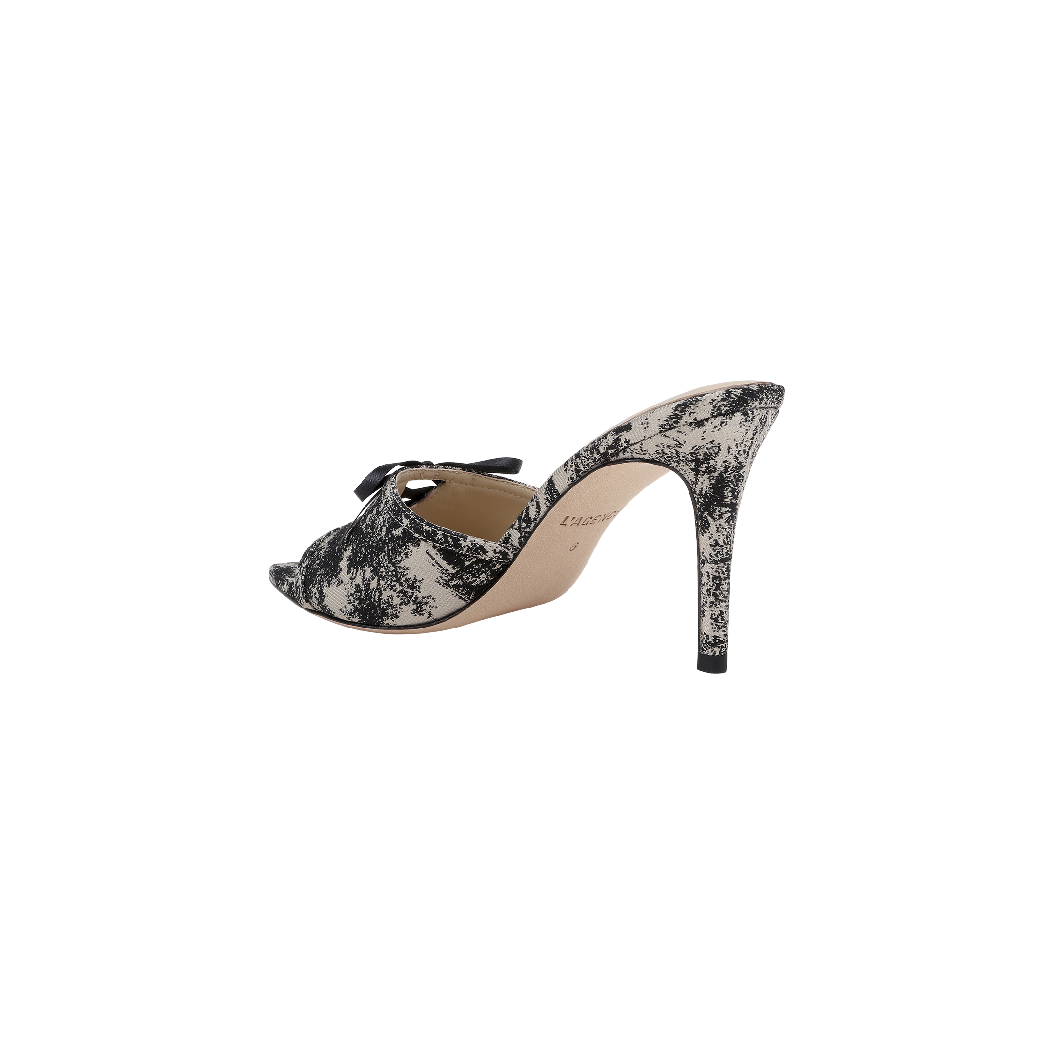 The Thames Sandal is a high-heeled mule featuring a black and white jungle brocade lace pattern, an open peep toe, a decorative bow on top, and a stiletto heel. The inside lining is tan, and the sandal is displayed against a plain white background.