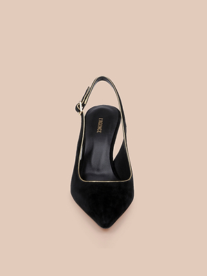 The Vichy Slingback Pump, in black suede with gold piping and buckle detail, is shown from above against a beige backdrop.