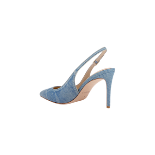 The Vichy Slingback Pump is a high-heeled, pointed-toe stiletto slingback crafted in light blue denim with a tan sole and slim stiletto heel, shown against a plain white background.