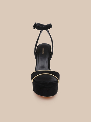 Front view of the Essie Platform Sandal in black suede, featuring an ankle strap and a thin gold accent on the toe strap, shown against a plain beige background.