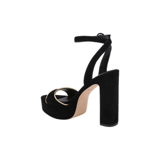 The Essie Platform Sandal is a black suede heeled sandal featuring a thick block heel, ankle strap, and a gold circular accent on the front strap, photographed against a plain white background.