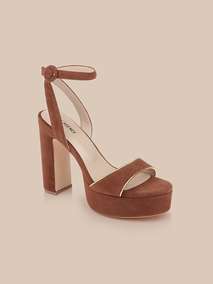 The Essie Platform Sandal is a brown suede heel with a thick platform, ankle strap, and elegant gold piping on the front strap, shown against a neutral beige background.