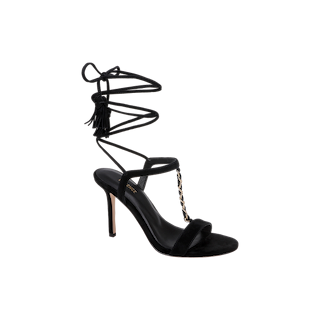 Bond Suede Sandal featuring a high strappy heel with a thin ankle wrap strap, tasseled ends, an open toe, and a gold chain detail on the front strap, set against a plain white background.