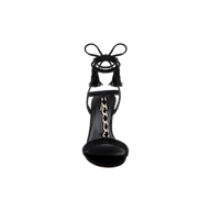 Front view of the Bond Suede Sandal in black, showcasing strappy heels with an ankle wrap featuring tassel accents and a gold chain detail along the insole, displayed against a white background.