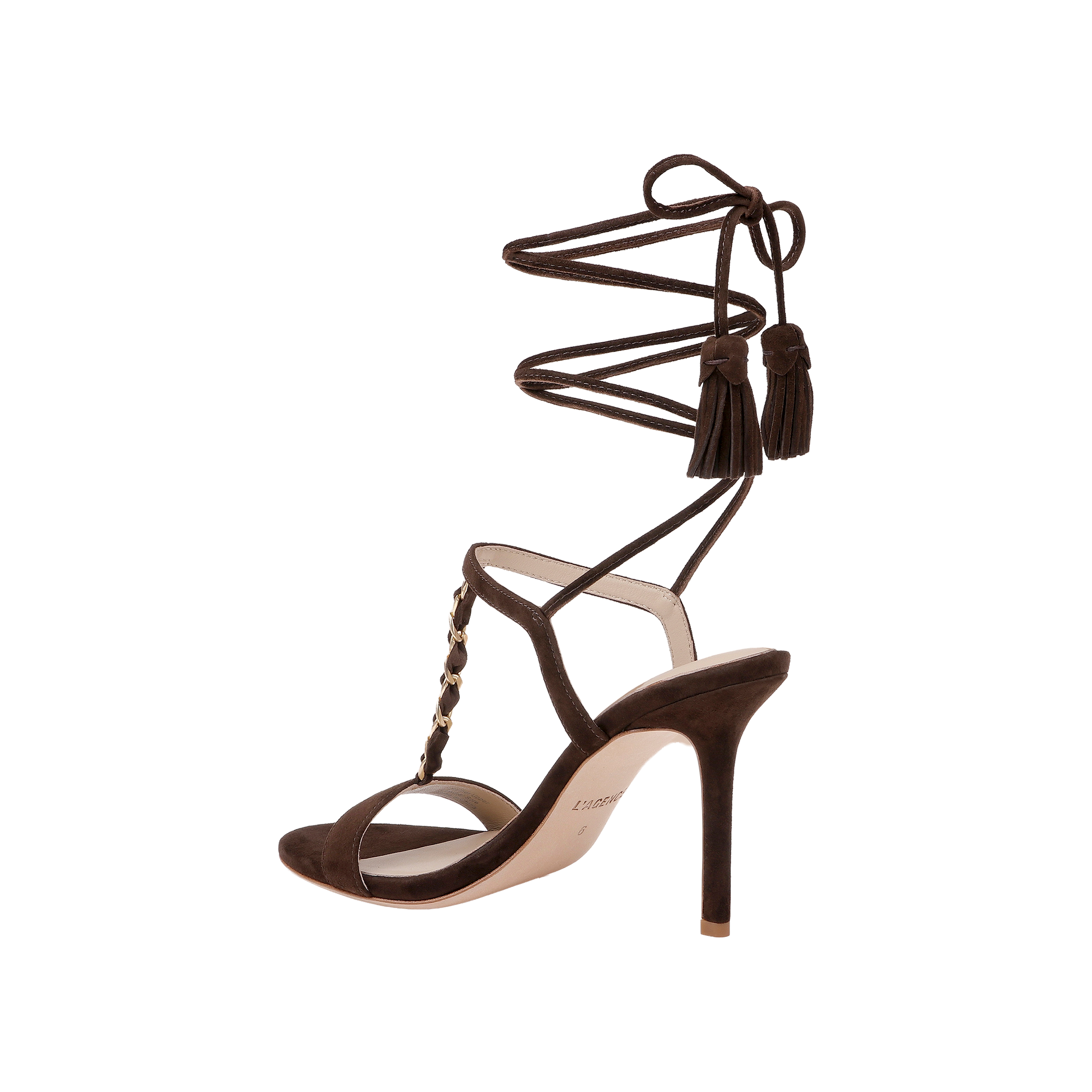The Bond Suede Sandal is a dark brown single sandal with a strappy heel design, ankle wrap straps, tassel accents, gold studs along the front, and an open toe, shown against a plain white background.