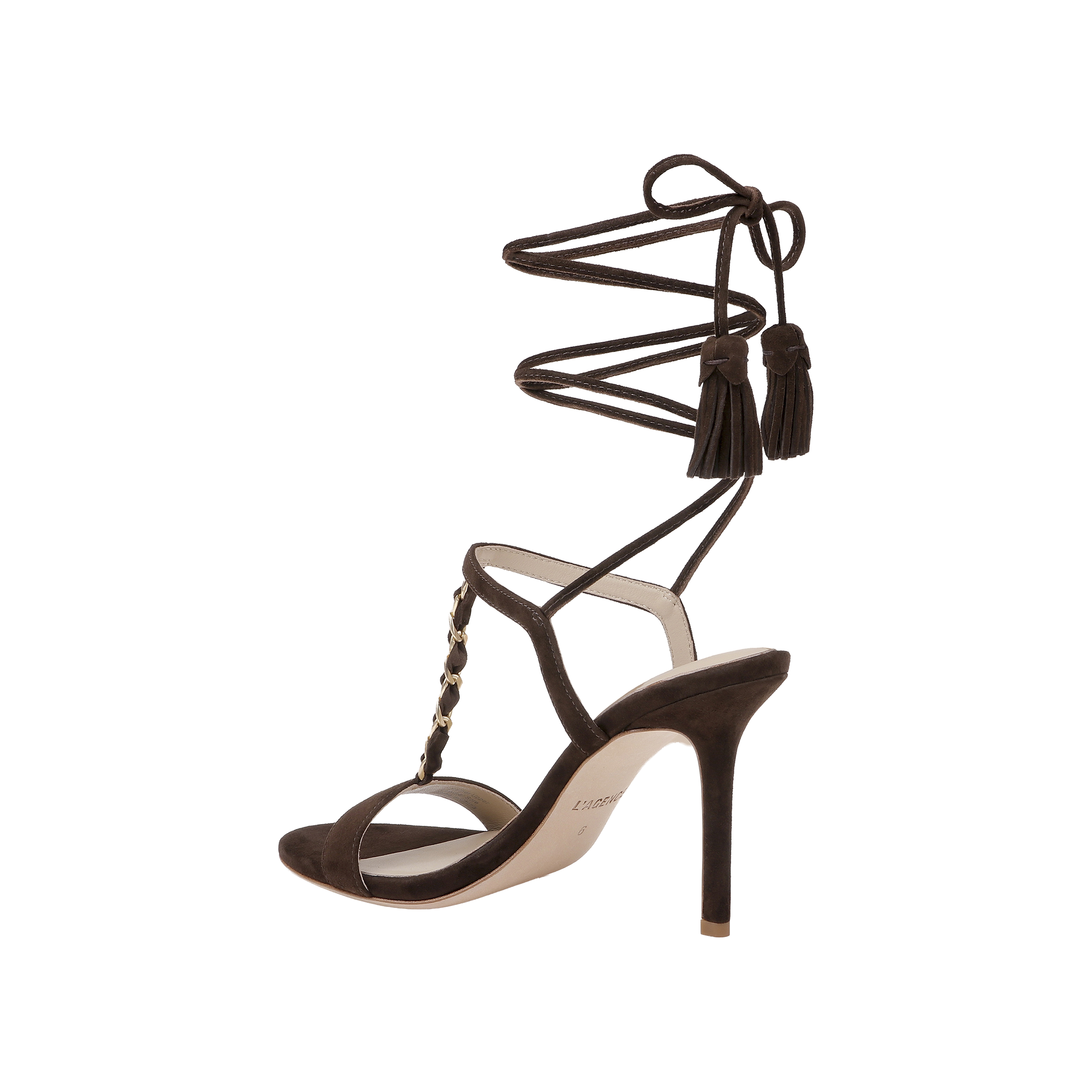 The Bond Suede Sandal is a dark brown single sandal with a strappy heel design, ankle wrap straps, tassel accents, gold studs along the front, and an open toe, shown against a plain white background.