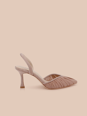 ‘Bowery Mesh Slingback Pump’는 러시드 메쉬 디자인과 뾰족한 앞코가 특징인 블러시 핑크색 하이힐로, 밝은 복숭아색 배경 위에 선보여집니다.